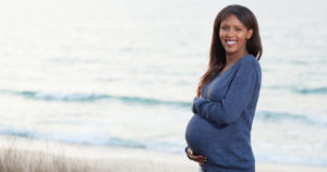 Pregnant woman smiling because she is well informed on her dental care during pregnancy
