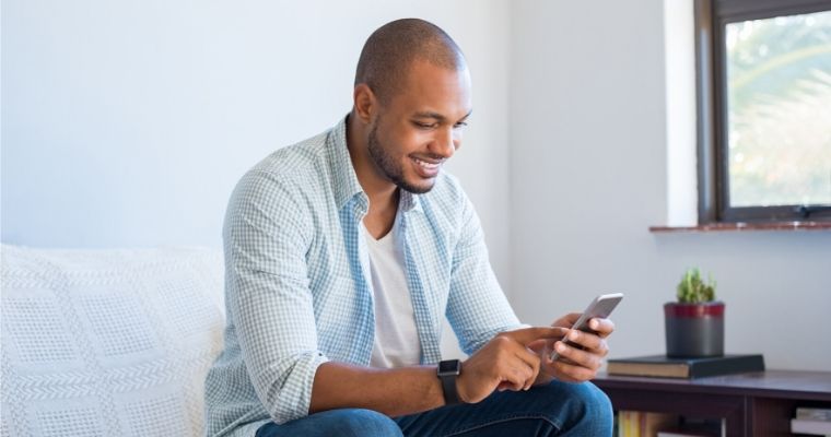 A man looking down at his online dental consultation on his phone