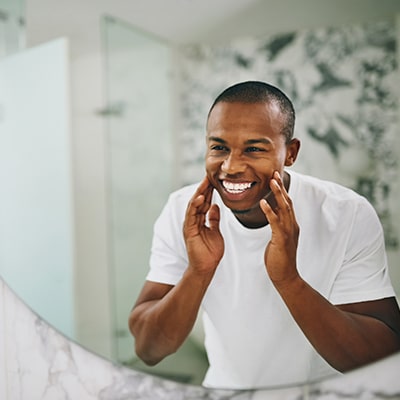 A young man looking at his new smile in the mirror